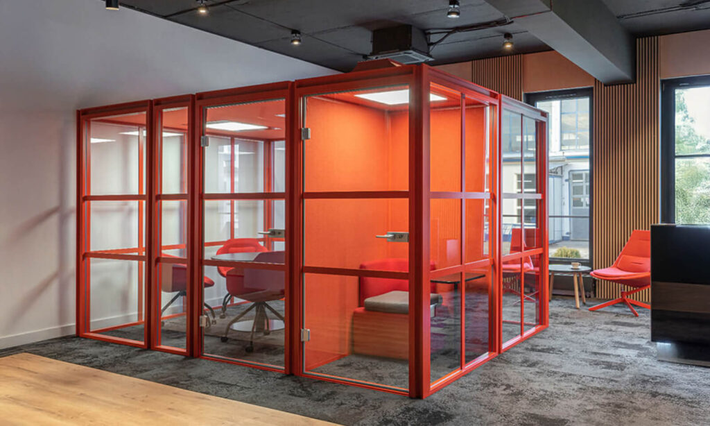 Acoustic booth offering a private and quiet workspace within an open office layout.